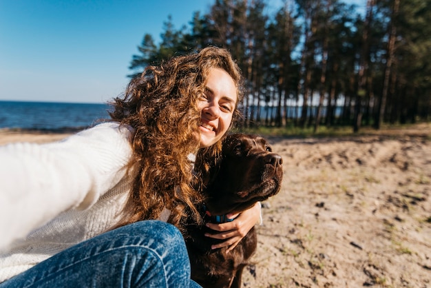 해변에서 그녀의 강아지와 함께 젊은 여성