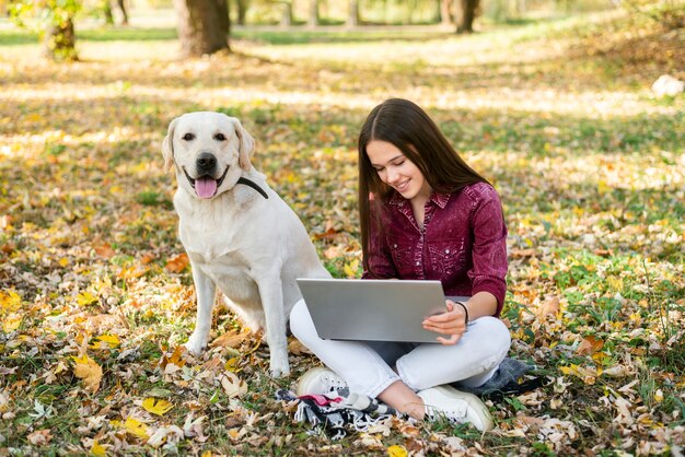 公園で彼女の犬を持つ若い女性