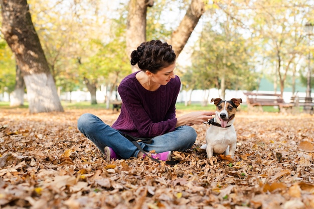 公園で彼女の犬を持つ若い女性
