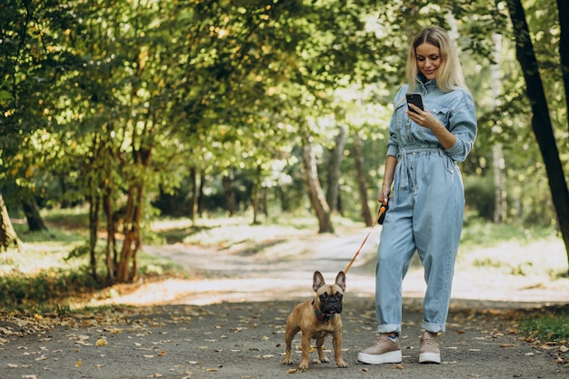 Young woman with her pet french bulldog in park