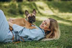 Free photo young woman with her pet french bulldog in park
