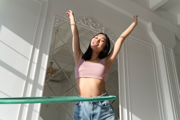 Free photo young woman with hula hoop