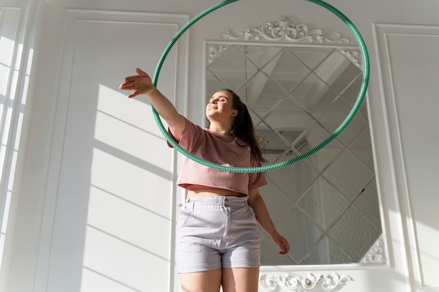 Free photo young woman with hula hoop