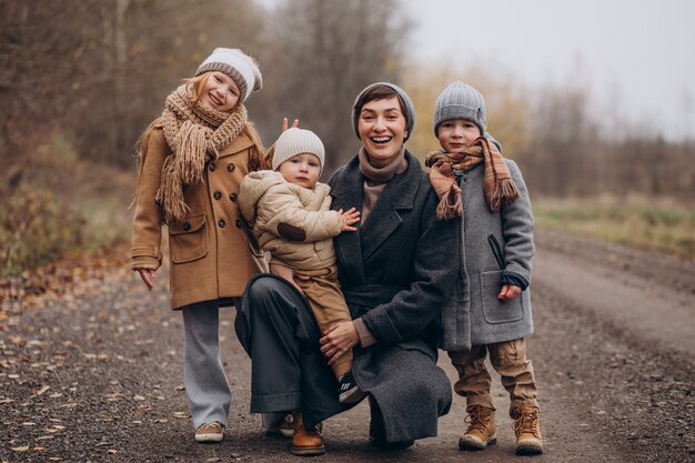 Young woman with kids walking in autumn park