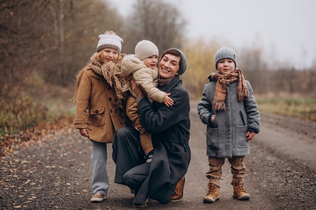 Young woman with kids walking in autumn park