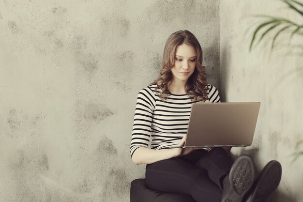 ラップトップpcコンピューターを持つ若い女