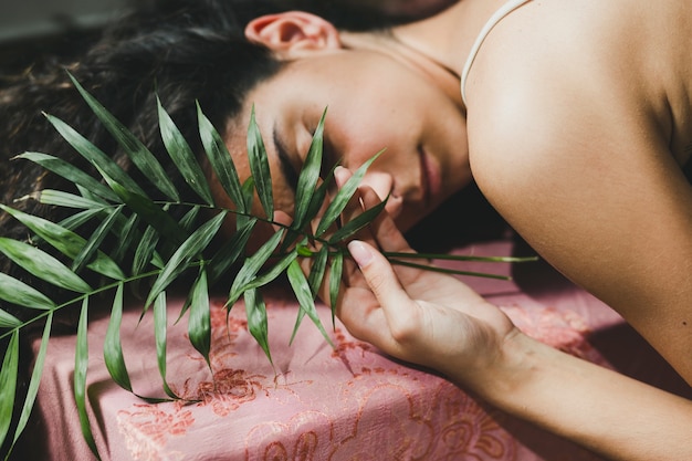 Free photo young woman with leaves sleeping