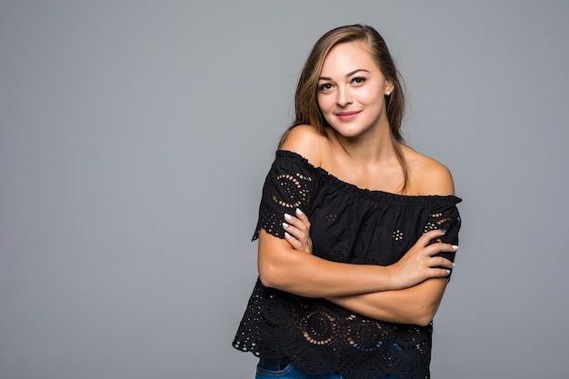 Young woman with long hair and black t-shirt posing on gray