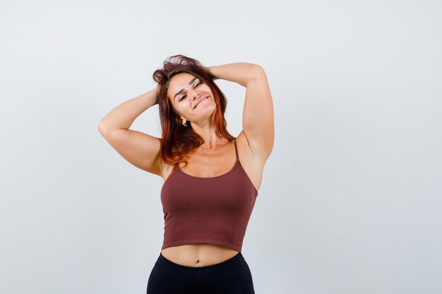 Young woman with long hair in a brown crop top