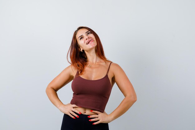 Young woman with long hair in a brown crop top