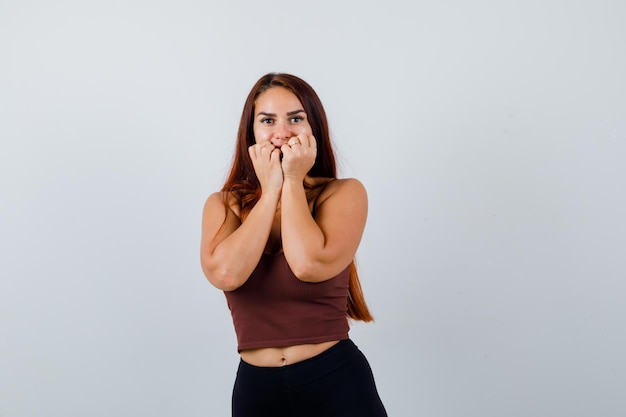 Young woman with long hair in a brown crop top