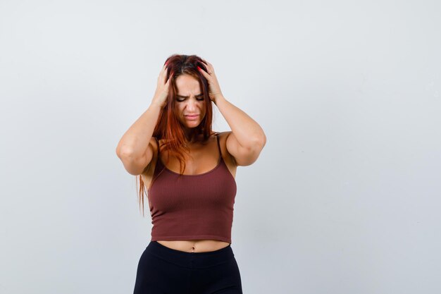 Young woman with long hair in a brown crop top