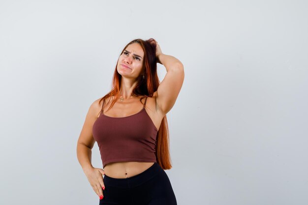 Young woman with long hair in a brown crop top