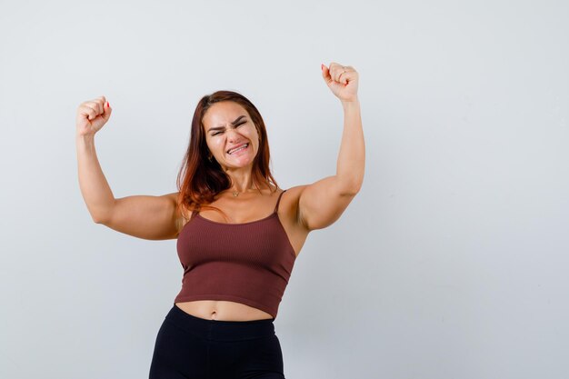 Young woman with long hair in a brown crop top