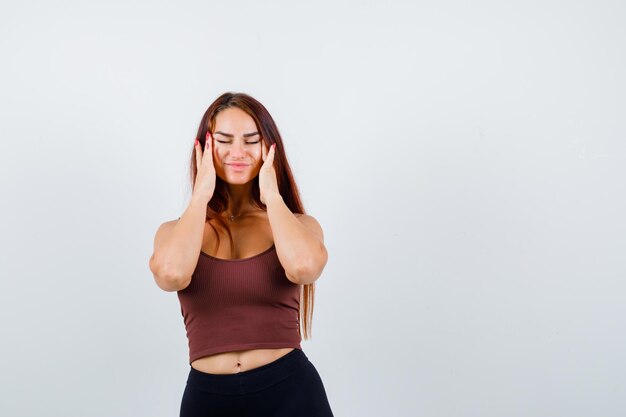 Young woman with long hair in a brown crop top