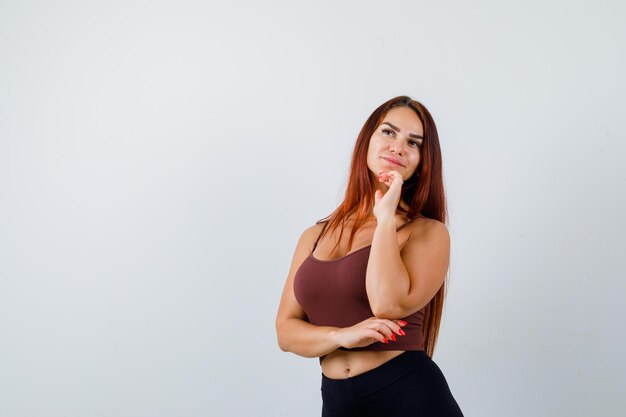 Young woman with long hair in a brown crop top