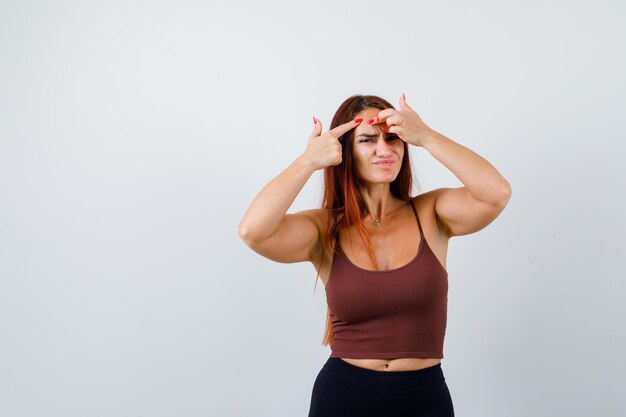 Giovane donna con i capelli lunghi in un top corto marrone