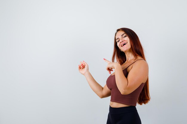 Young woman with long hair in a brown crop top