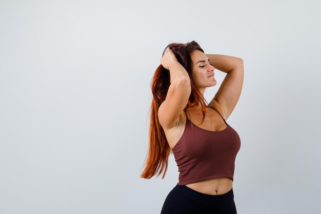 Young woman with long hair in a brown crop top