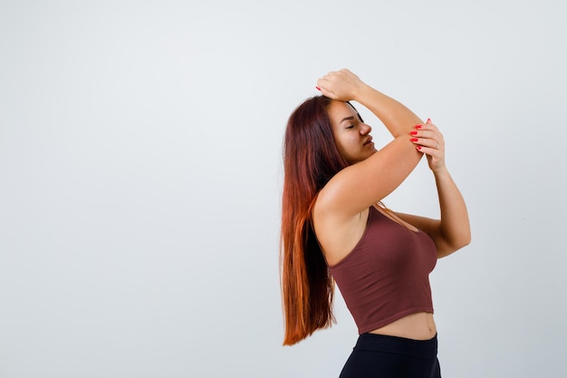 Young woman with long hair in a brown crop top