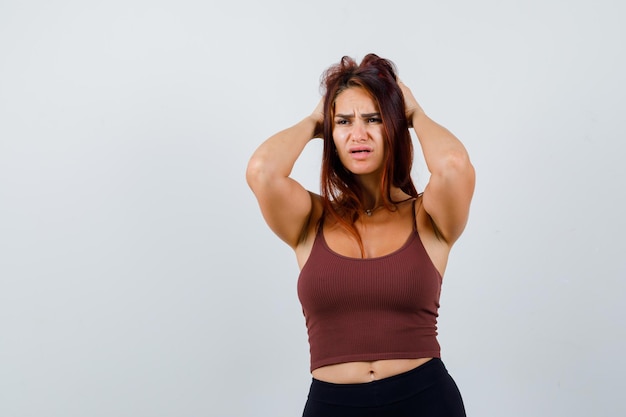 Foto gratuita giovane donna con i capelli lunghi in un top corto marrone