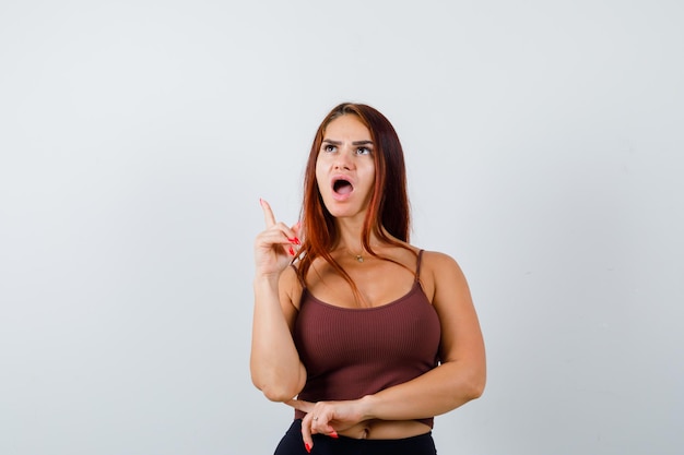 Foto gratuita giovane donna con i capelli lunghi in un top corto marrone