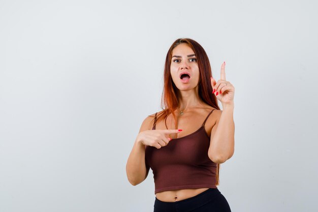 Young woman with long hair in a brown crop top