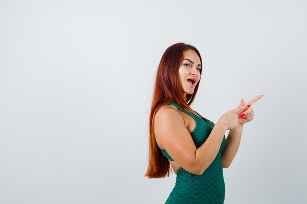 Young woman with long hair in a green bodycon