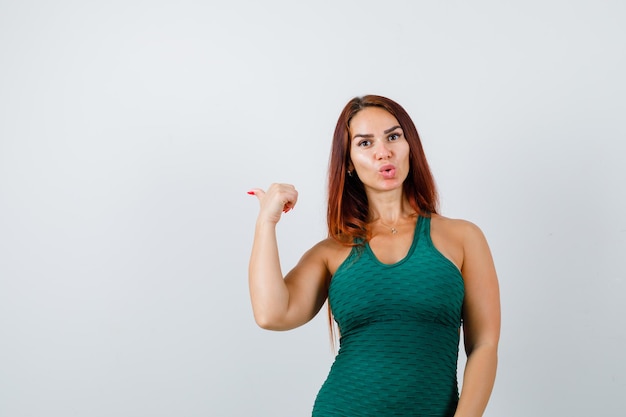 Young woman with long hair in a green bodycon