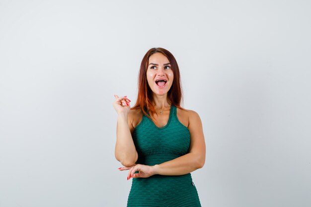 Free photo young woman with long hair in a green bodycon