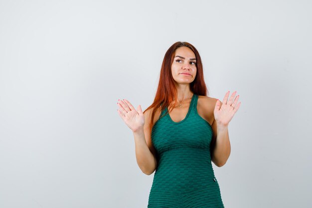 Young woman with long hair in a green bodycon