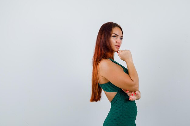 Young woman with long hair in a green bodycon