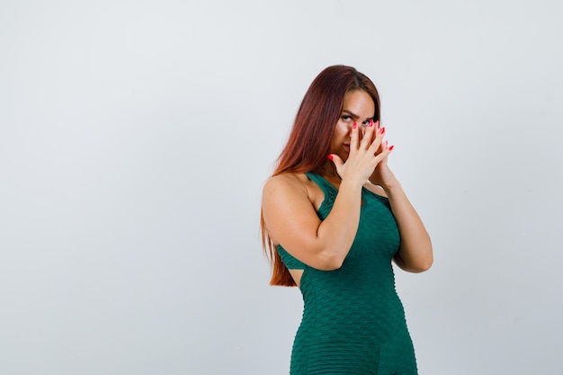 Foto gratuita giovane donna con i capelli lunghi in un bodycon verde