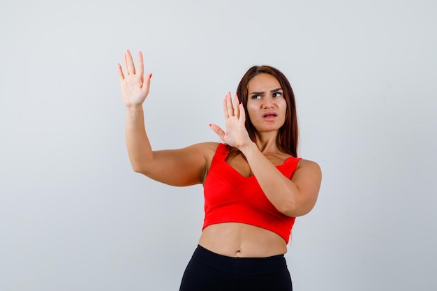 Foto gratuita giovane donna con i capelli lunghi in una canottiera arancione