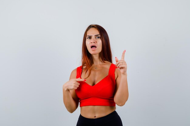 Young woman with long hair in an orange tank top