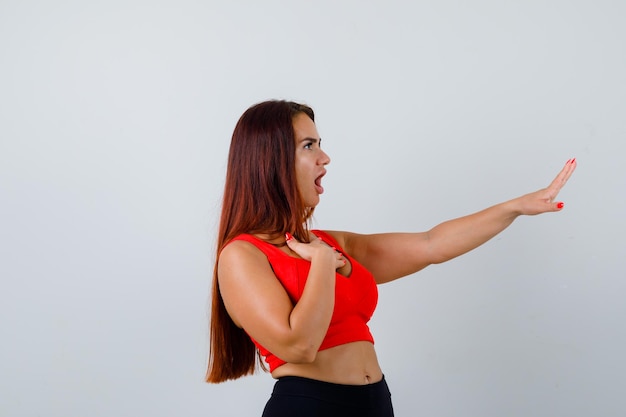 Giovane donna con i capelli lunghi in una canottiera arancione