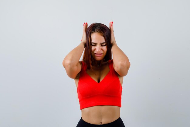 Young woman with long hair in an orange tank top