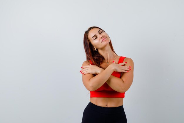 Young woman with long hair in an orange tank top