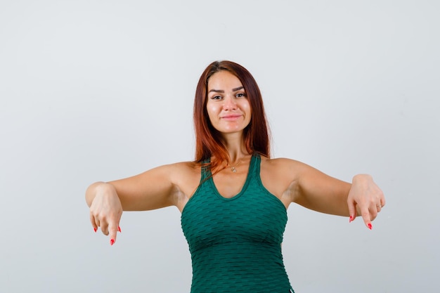 Giovane donna con i capelli lunghi che indossa un bodycon verde