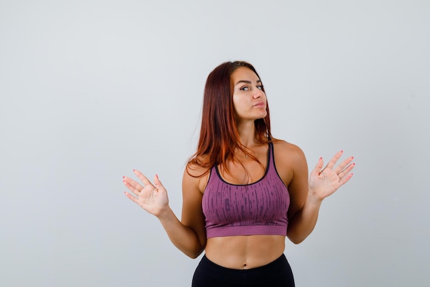 Giovane donna con i capelli lunghi che indossa abbigliamento sportivo