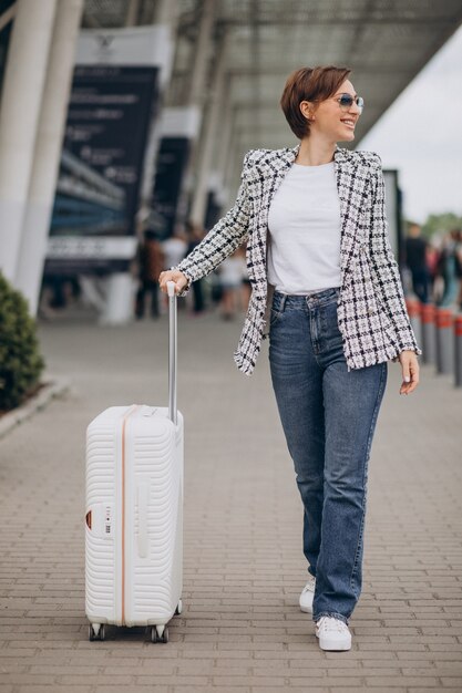 공항 여행에서 수화물을 가진 젊은 여자