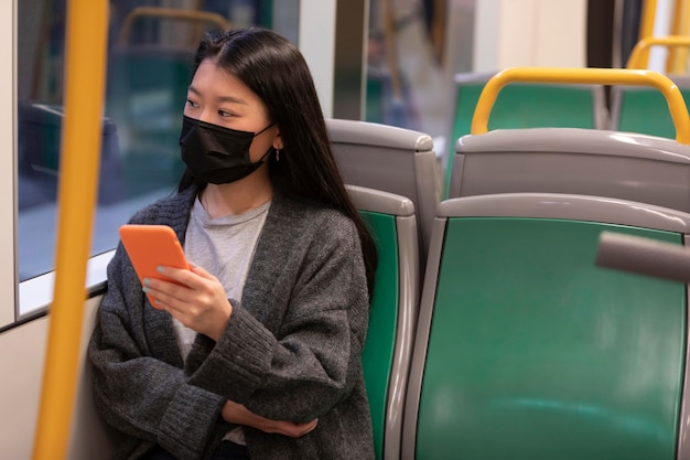 Giovane donna con la maschera in autobus