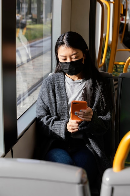 Foto gratuita giovane donna con la maschera in autobus