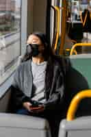 Foto gratuita giovane donna con la maschera in autobus