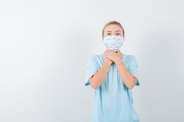 Young woman with a medical mask having a sore throat