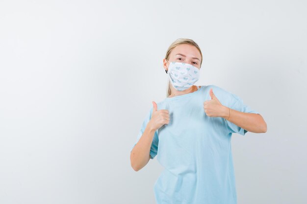 Young woman with a medical mask showing thumbs up