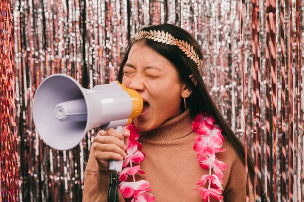 Young woman with megaphone at carnival party