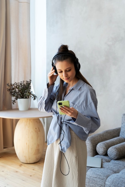 Young woman with messy bun listening to music