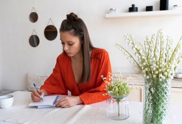 Free photo young woman with messy bun working from home