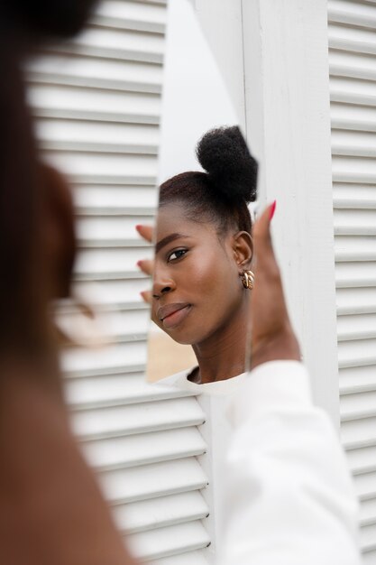 Young woman with mirror outside